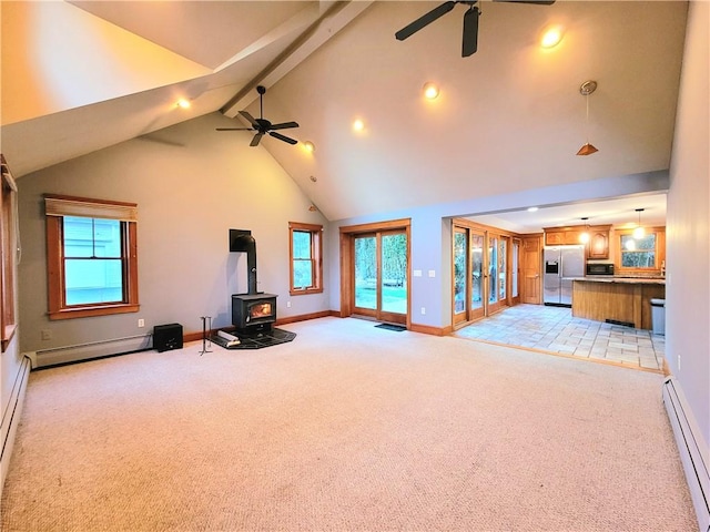 unfurnished living room featuring a wood stove, a ceiling fan, and a baseboard radiator