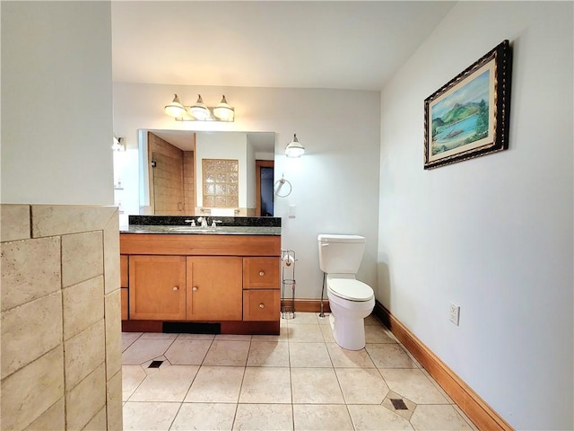 bathroom with tile patterned flooring, toilet, vanity, and baseboards