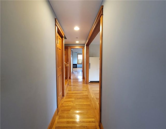 corridor with recessed lighting, baseboards, and light wood finished floors