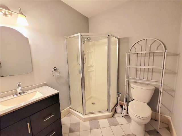 bathroom featuring vanity, toilet, baseboards, and a stall shower