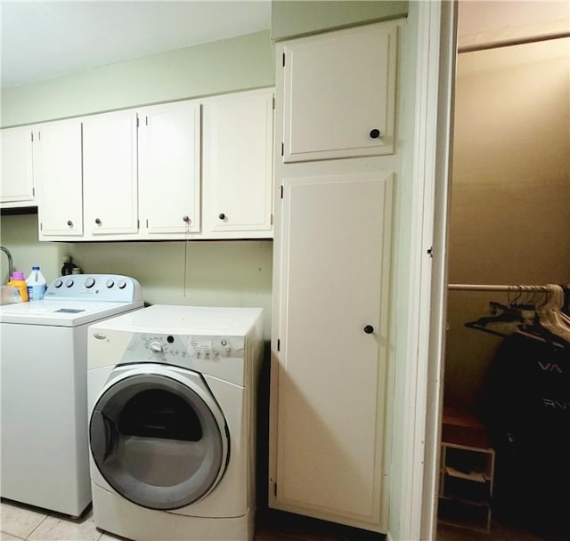 clothes washing area featuring cabinet space and washing machine and dryer