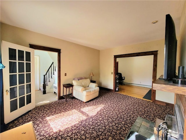 living area featuring stairway, baseboards, and a baseboard radiator