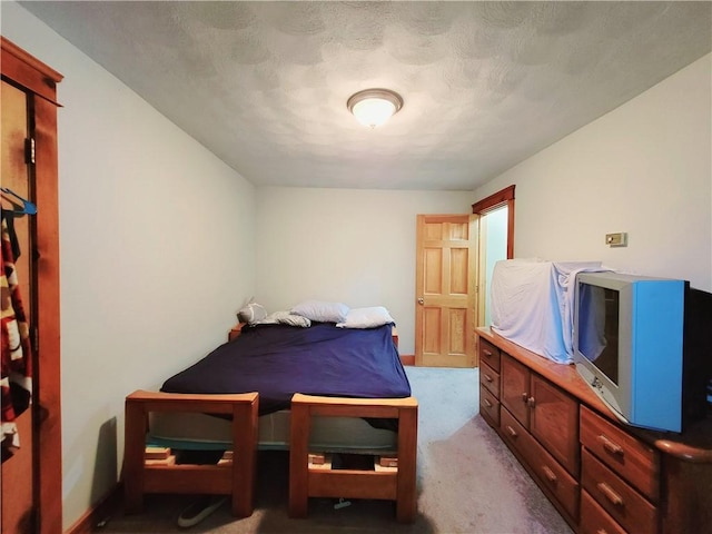 carpeted bedroom featuring a textured ceiling