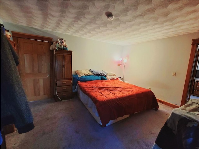 carpeted bedroom featuring baseboards and a textured ceiling