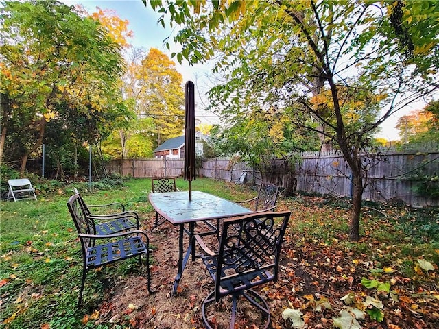 view of yard with outdoor dining area and a fenced backyard