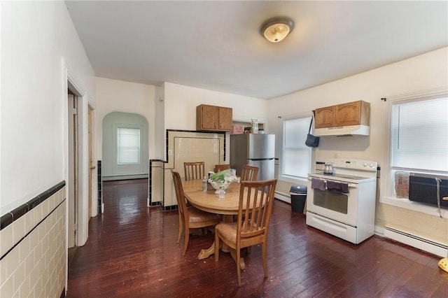 kitchen with a baseboard heating unit, baseboard heating, freestanding refrigerator, white electric range oven, and dark wood-style floors