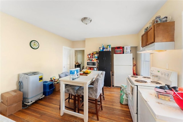 kitchen with under cabinet range hood, light wood-style flooring, white appliances, and brown cabinets