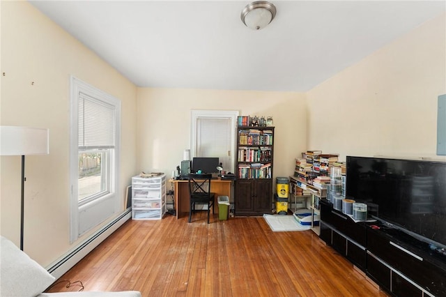 office space featuring a baseboard radiator and hardwood / wood-style flooring