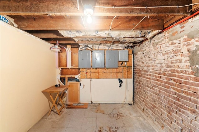 unfinished below grade area featuring electric panel and brick wall