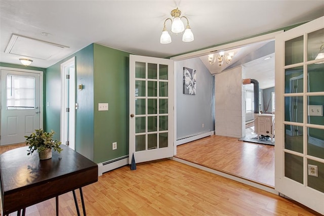 doorway featuring a baseboard heating unit, light wood-style flooring, and a healthy amount of sunlight