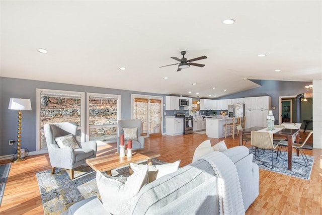 living area featuring vaulted ceiling, recessed lighting, light wood-type flooring, and ceiling fan