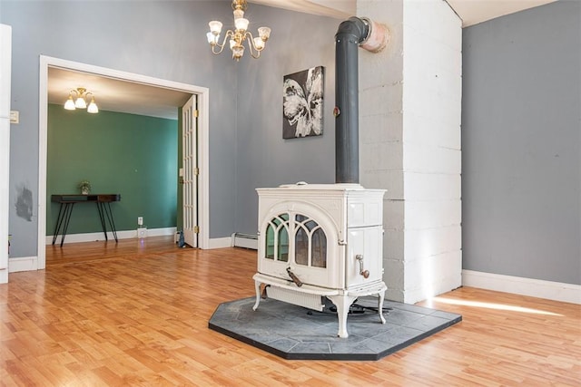 details with wood finished floors, baseboards, a baseboard radiator, a wood stove, and a chandelier