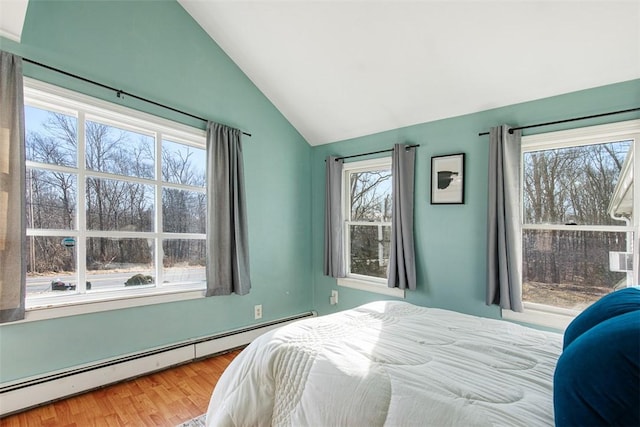 bedroom featuring a baseboard heating unit, vaulted ceiling, and wood finished floors