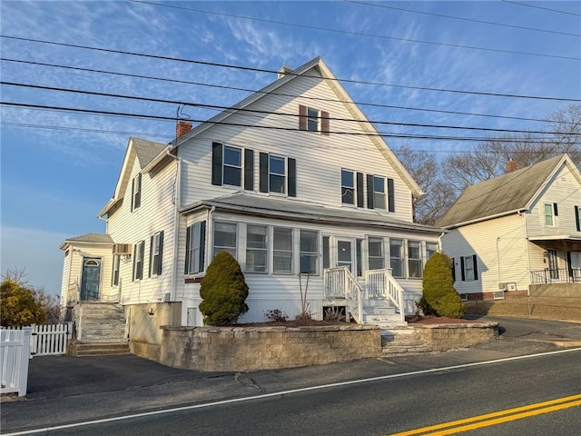 view of front of property featuring a chimney and fence