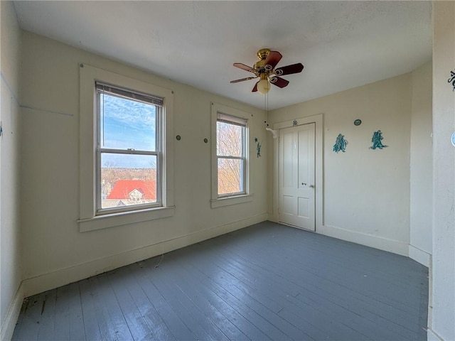 spare room featuring baseboards, a ceiling fan, and hardwood / wood-style floors