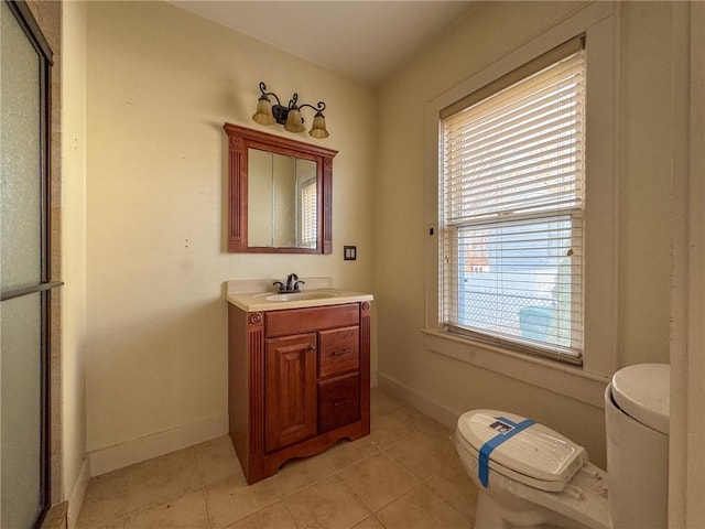 bathroom featuring baseboards, toilet, vanity, and tile patterned flooring