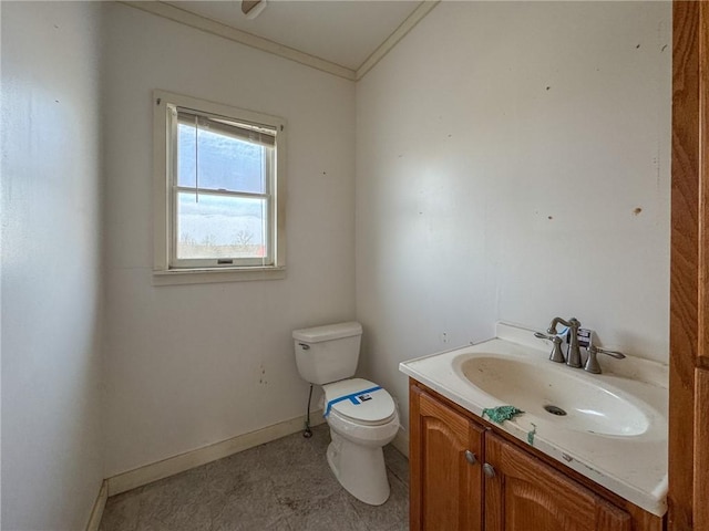 bathroom featuring crown molding, toilet, vanity, and baseboards