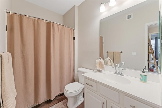 full bathroom featuring vanity, a shower with curtain, wood finished floors, visible vents, and toilet