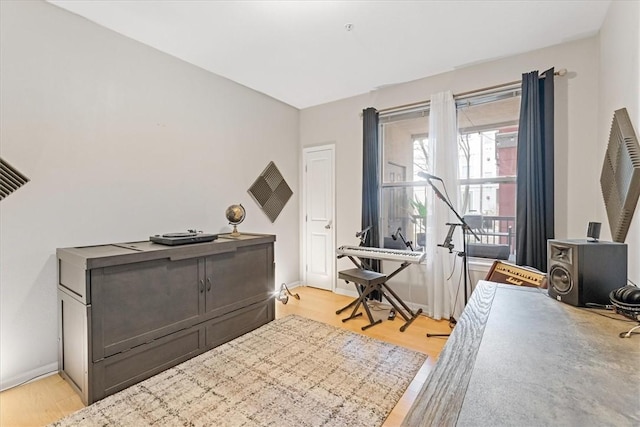 home office with light wood-style flooring and baseboards