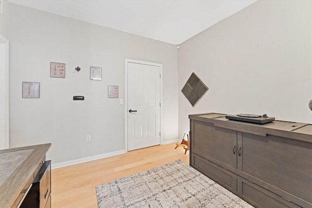 interior space with baseboards and light wood finished floors