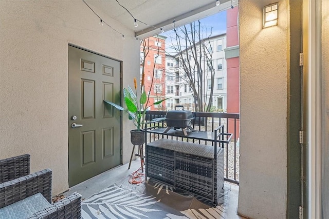 entrance to property with stucco siding and a balcony