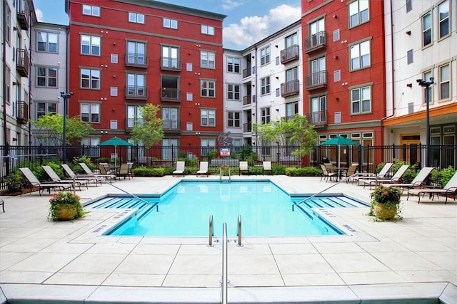 community pool featuring a patio and fence