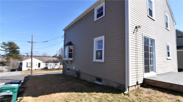 view of side of home featuring a wooden deck and a yard