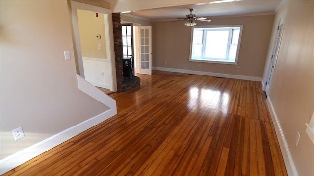 spare room featuring crown molding, a ceiling fan, baseboards, and wood-type flooring