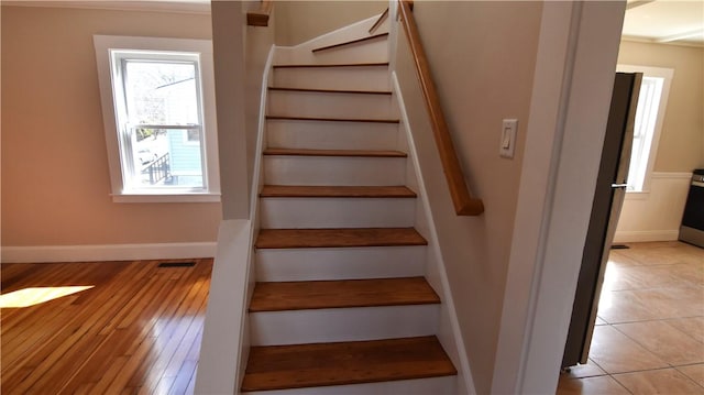 staircase featuring visible vents, baseboards, and wood finished floors