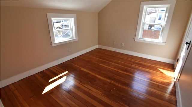 additional living space with dark wood finished floors, baseboards, and lofted ceiling