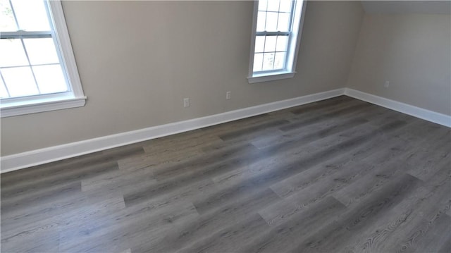 empty room with dark wood finished floors and baseboards