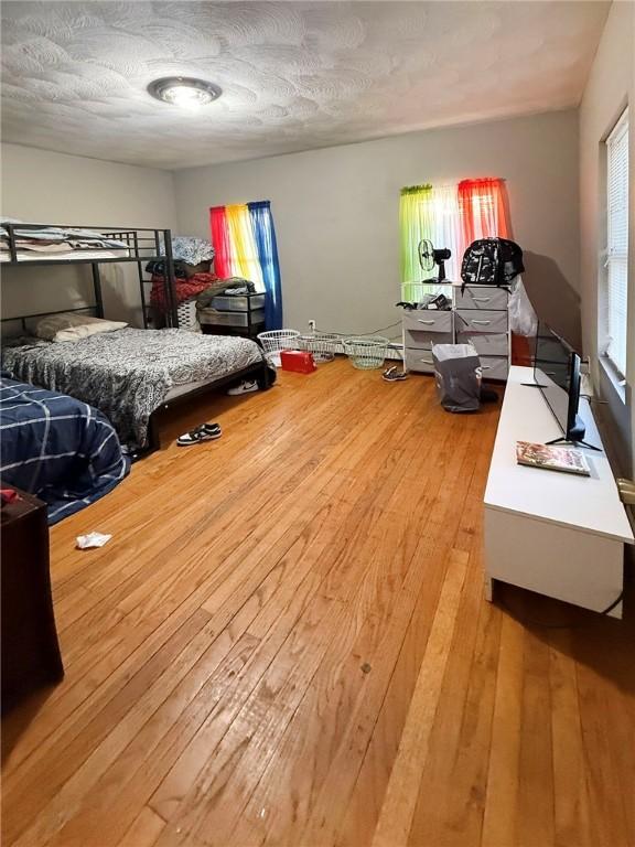 bedroom with a textured ceiling and hardwood / wood-style floors