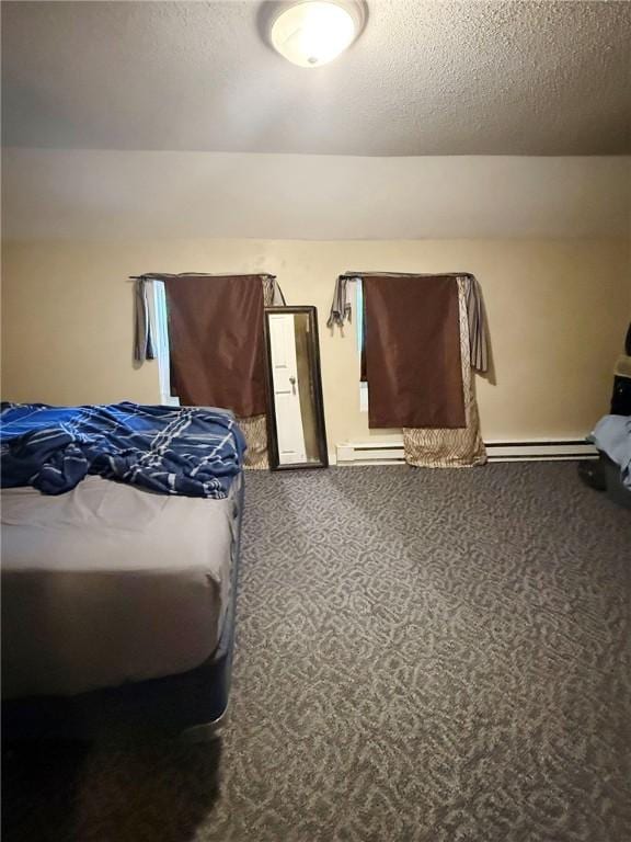 bedroom with baseboard heating, carpet flooring, and a textured ceiling