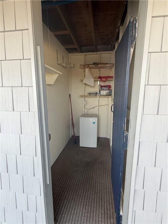 exterior space with dark carpet and fridge