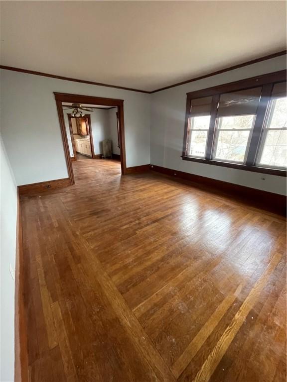 51 Oakland Ave, Cranston, RI 02910 - spare room with baseboards, ornamental molding, wood finished floors, and radiator