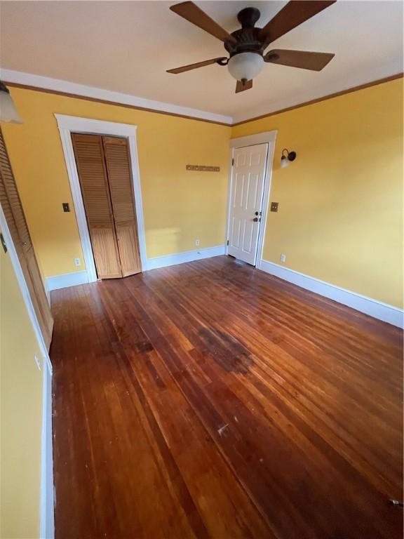 51 Oakland Ave, Cranston, RI 02910 - unfurnished bedroom with crown molding, a ceiling fan, baseboards, and dark wood-style floors