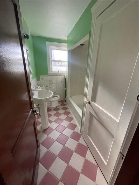51 Oakland Ave, Cranston, RI 02910 - full bath featuring toilet, tile walls, tile patterned floors, a sink, and combined bath / shower with glass door
