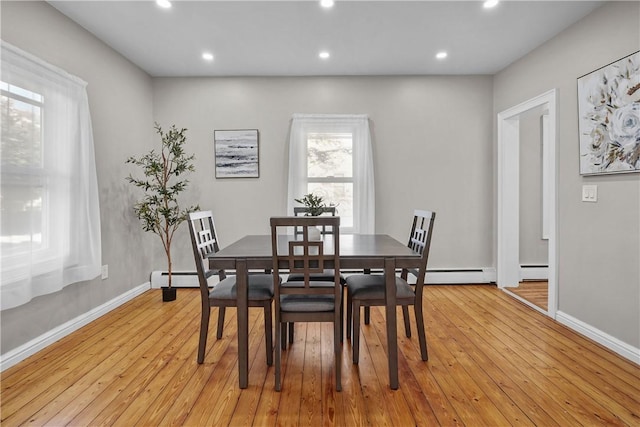 dining area featuring light wood finished floors, baseboard heating, recessed lighting, and baseboards