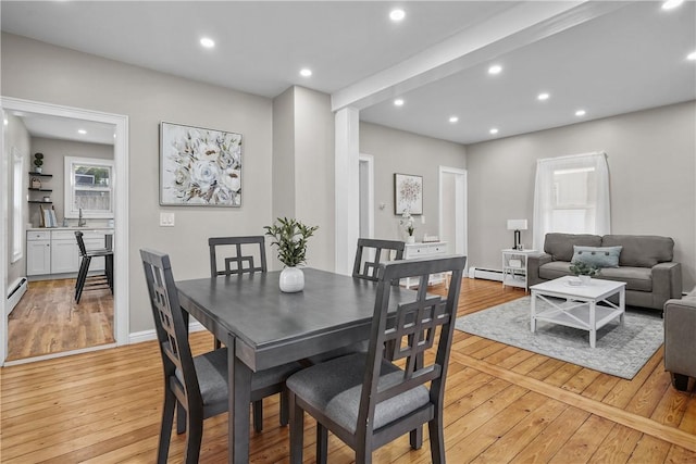 dining room featuring recessed lighting, a baseboard heating unit, baseboards, and light wood finished floors