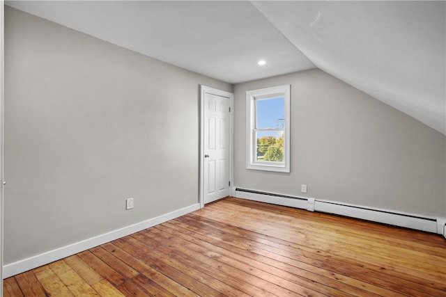 additional living space featuring vaulted ceiling, baseboards, wood-type flooring, and a baseboard radiator