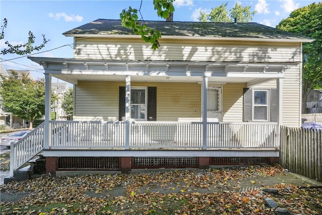 rear view of property featuring covered porch