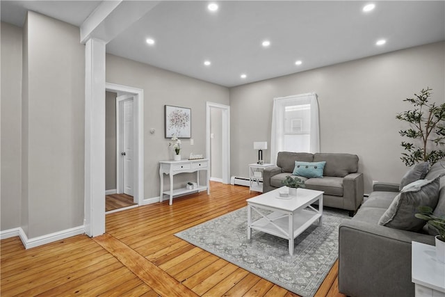 living area featuring recessed lighting, a baseboard radiator, baseboards, and light wood-style flooring