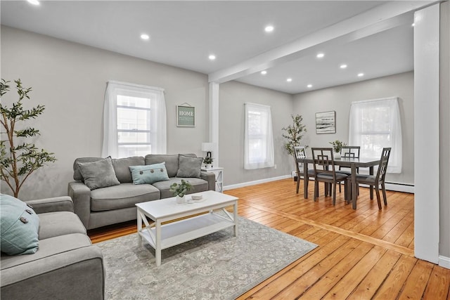 living area featuring recessed lighting, baseboards, baseboard heating, and light wood-style flooring