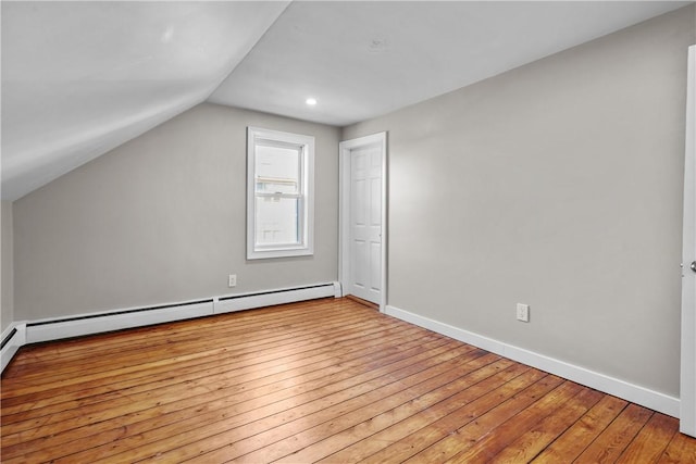 additional living space with vaulted ceiling, a baseboard radiator, baseboards, and wood-type flooring