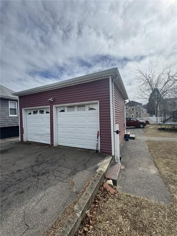 garage with aphalt driveway and a trampoline