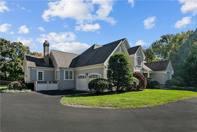50 Kenyon Ave, East Greenwich, RI 02818 - view of front facade featuring driveway, a chimney, a garage, and a front yard
