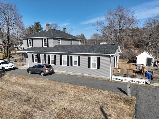 view of front of property featuring a chimney and a shingled roof