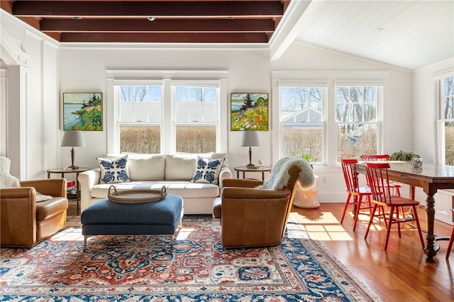 sunroom / solarium featuring vaulted ceiling with beams