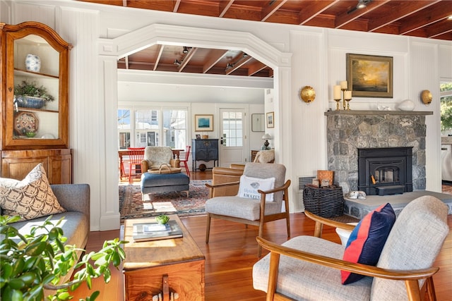 living area with beam ceiling and wood finished floors