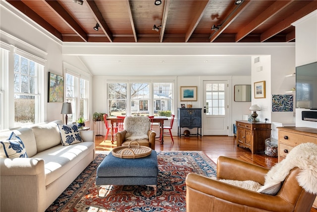 living room with vaulted ceiling with beams and wood finished floors